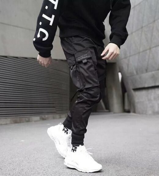 Man in techwear jogger pants stepping forwards